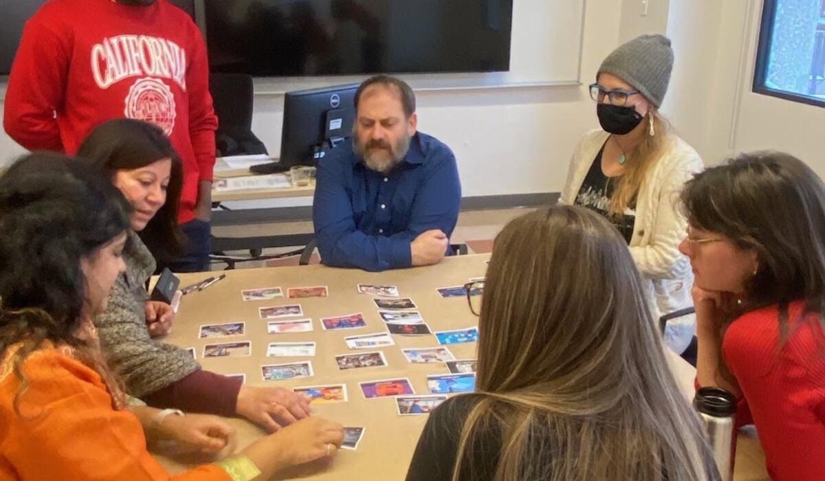 Participant·es autour d'une table de cartes de la Fresque critique de l'IA